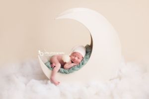 newborn photography - baby boy is sleeping on a moon prop