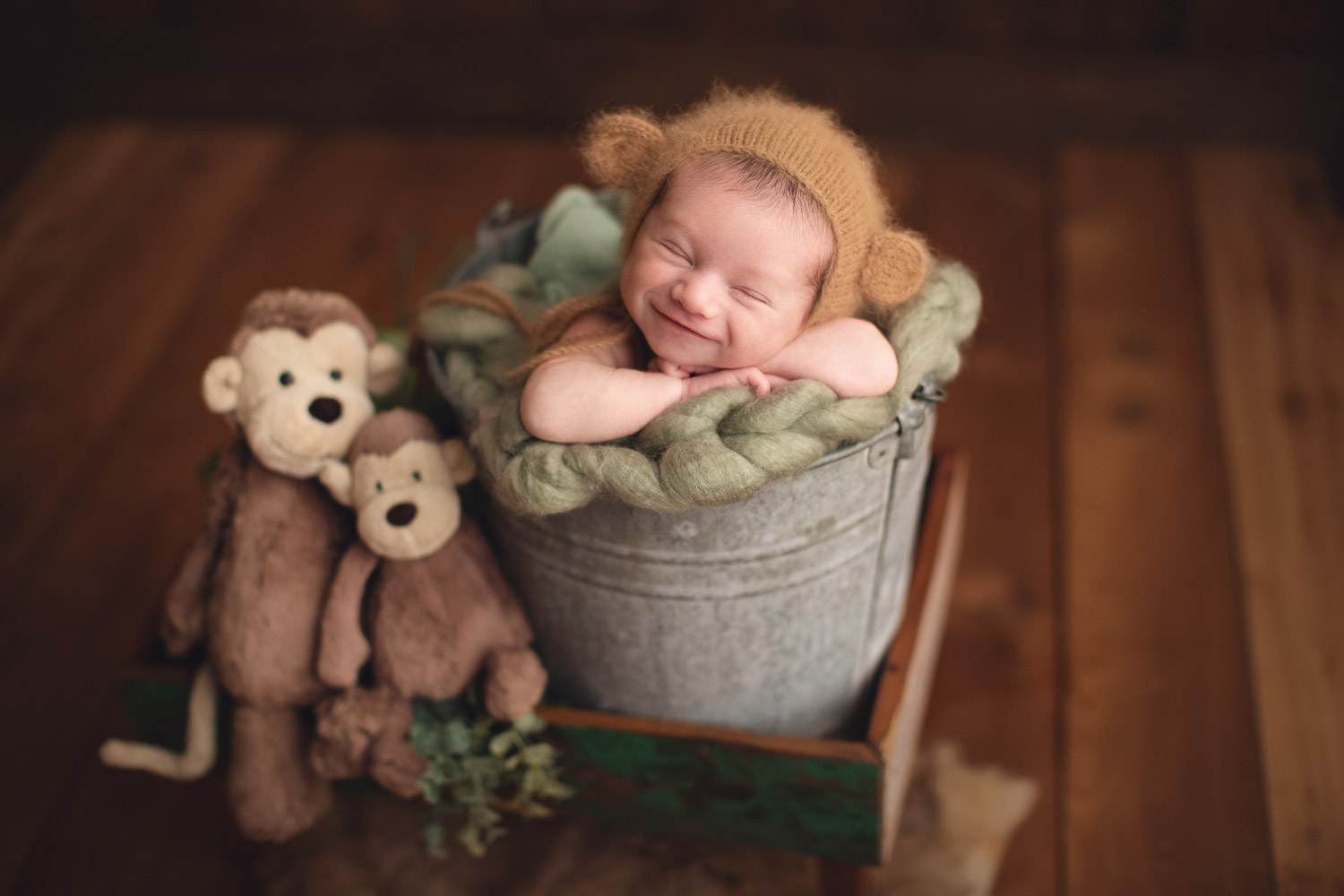 Vancouver newborn photography baby boy in a brown bucket and smile