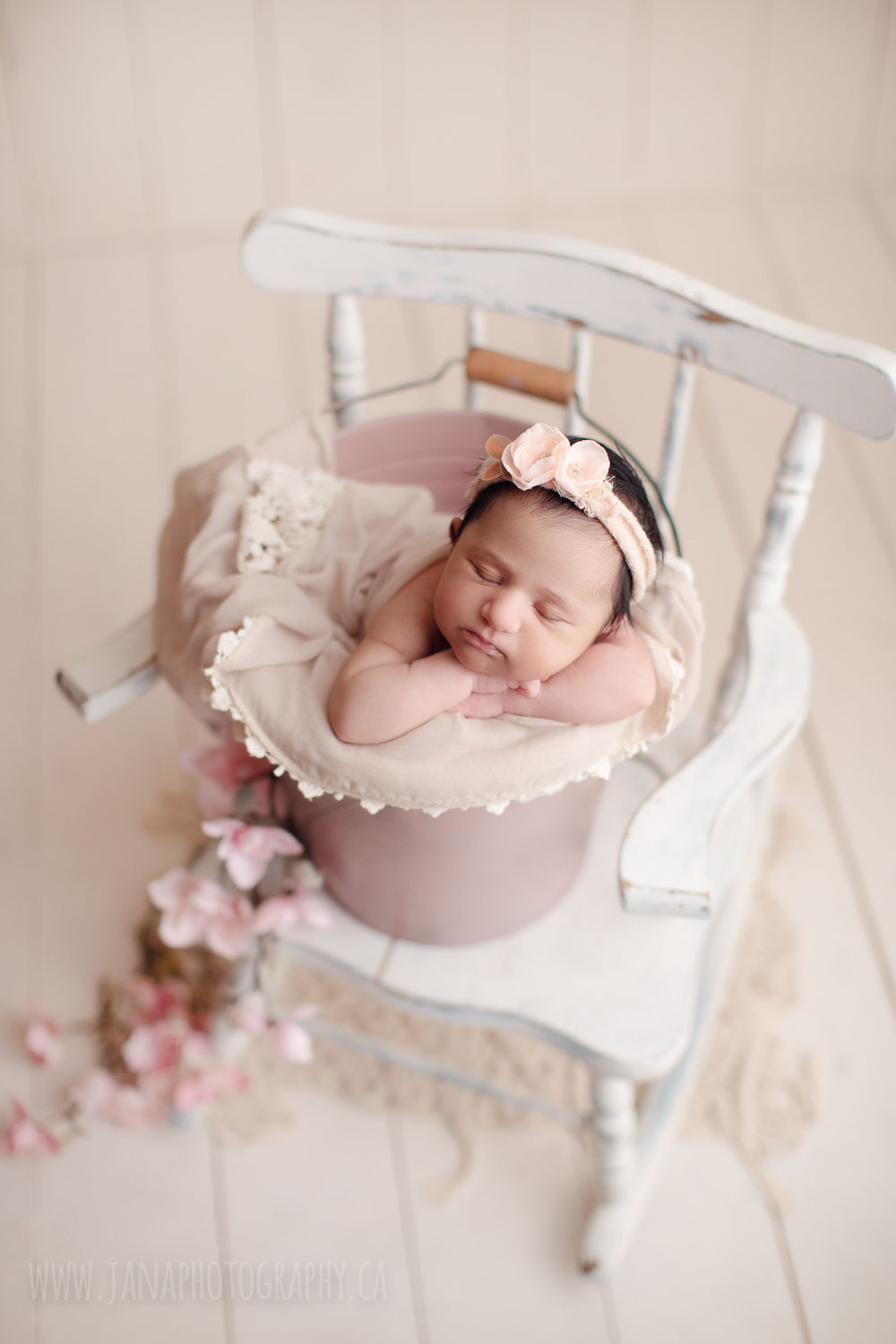 newborn baby girl in a pink bucket and white chair - Vancouver - janaphotography
