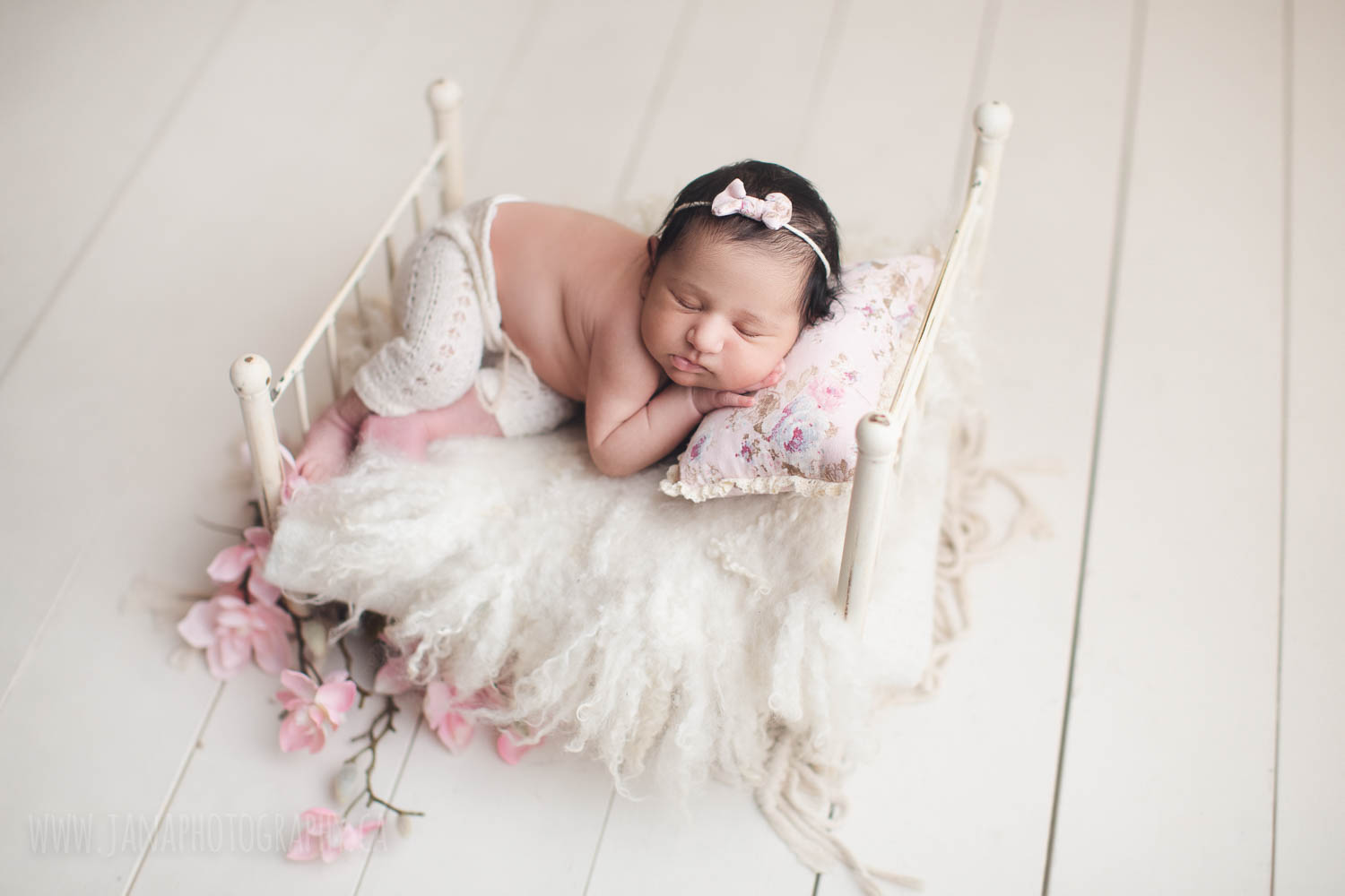 newborn photography - baby girl sleeping in a white bed