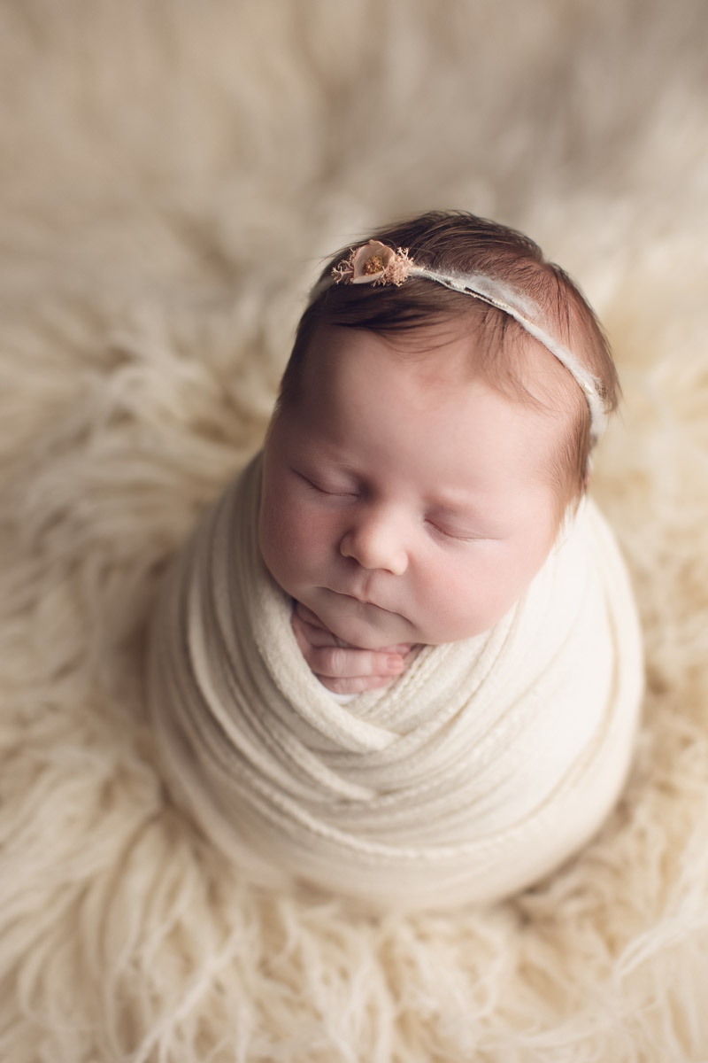 newborn baby girl smiles in yellow background - crown