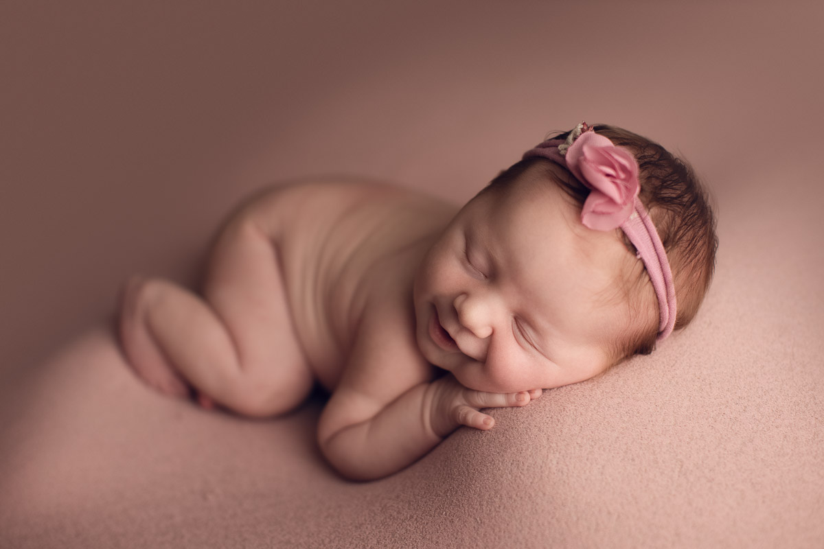 how to make baby smile - newborn pink background