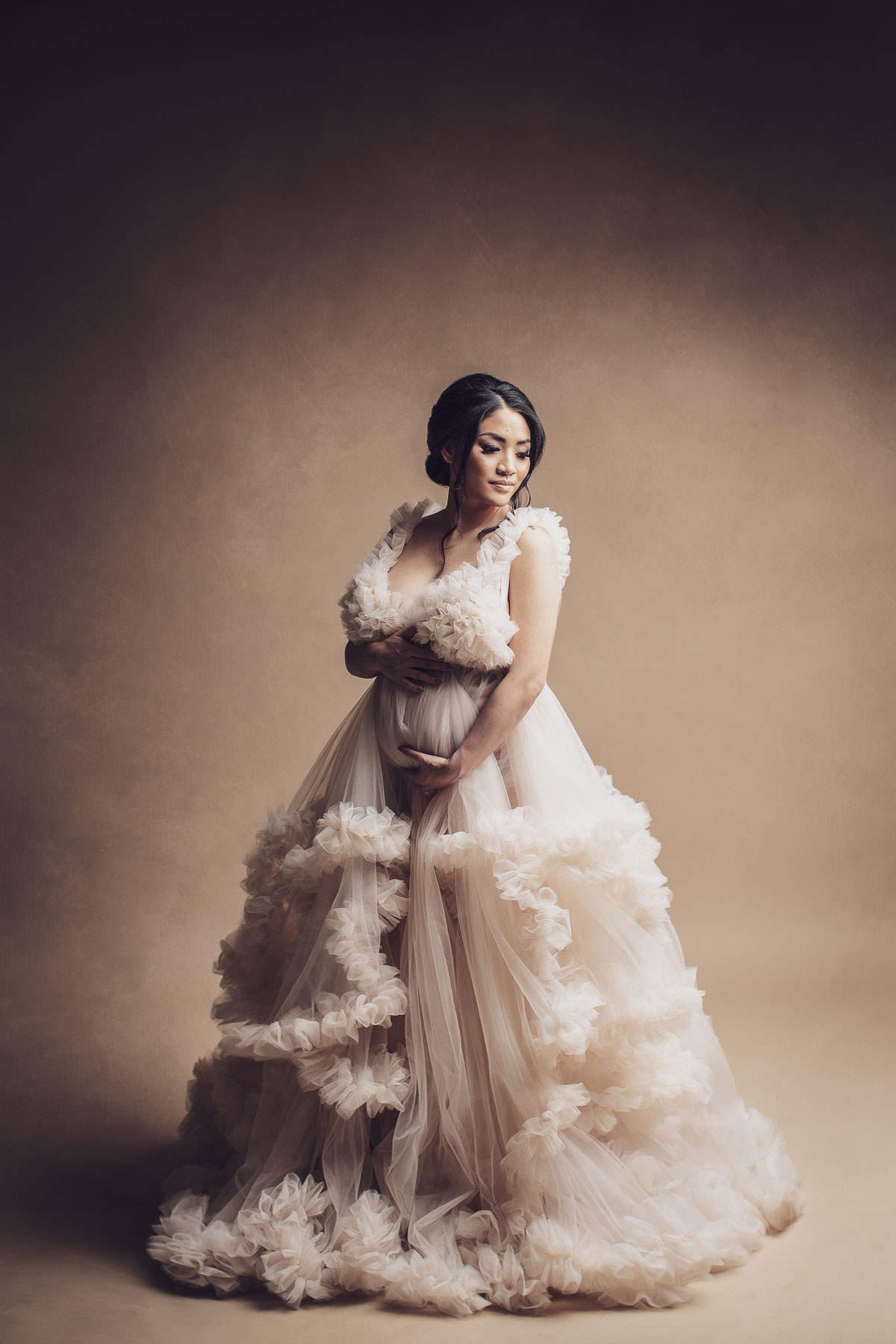 fine art studio lighting maternity photo with beautiful blush color couture gown