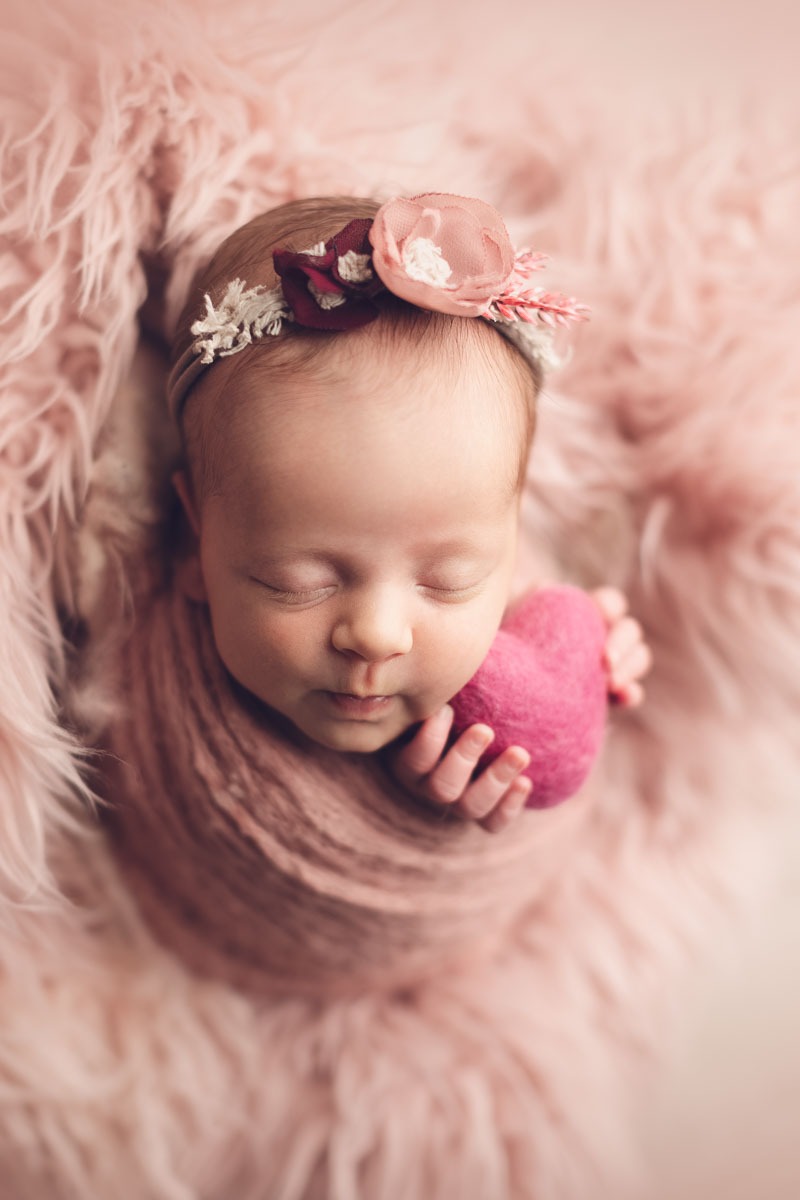 Vancouver - Burnaby and surrey - newborn photography - baby girl holding a pink heart in a pink flokati