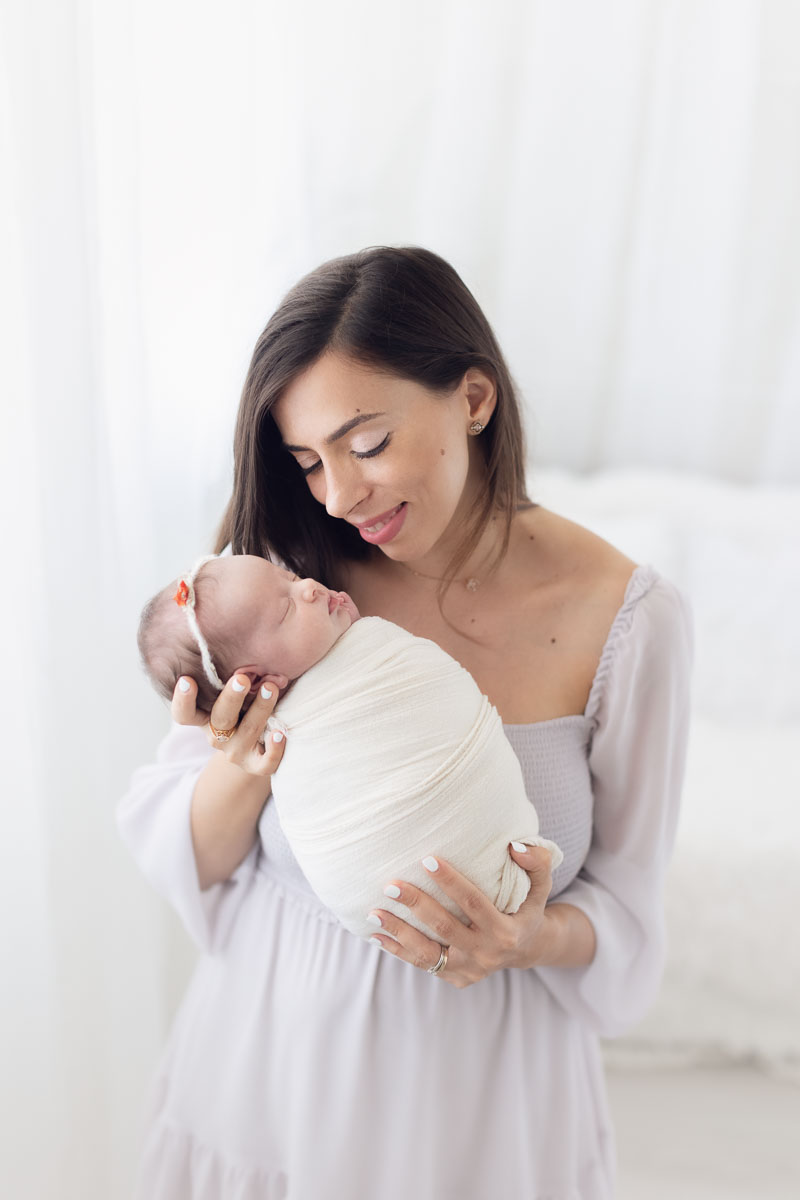 Vancouver - Burnaby and surrey - newborn photography - mom holding baby girl on a natural light studio